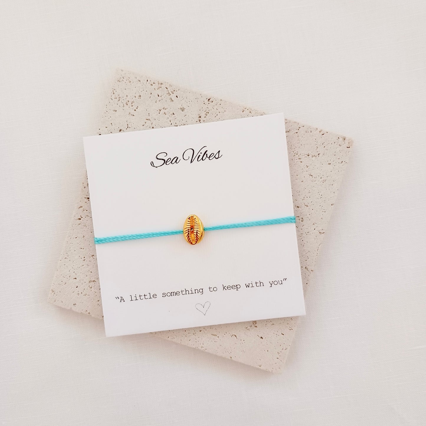 Gold shell charm cord bracelet