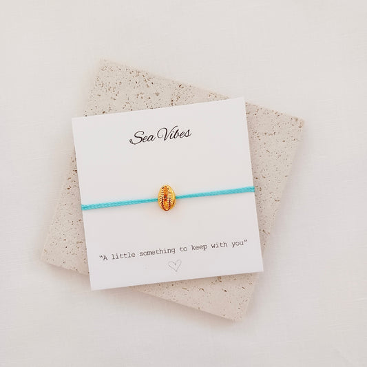 Gold shell charm cord bracelet