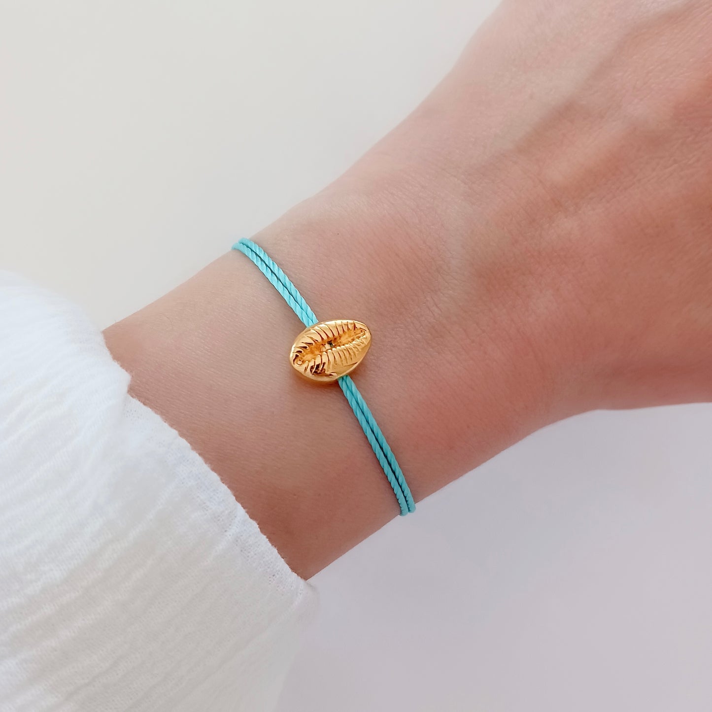 Gold shell charm cord bracelet