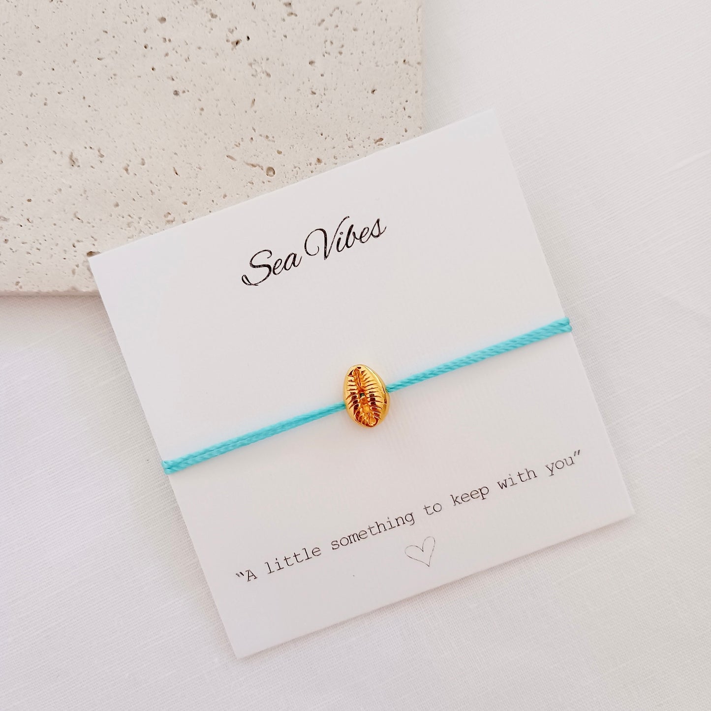 Gold shell charm cord bracelet