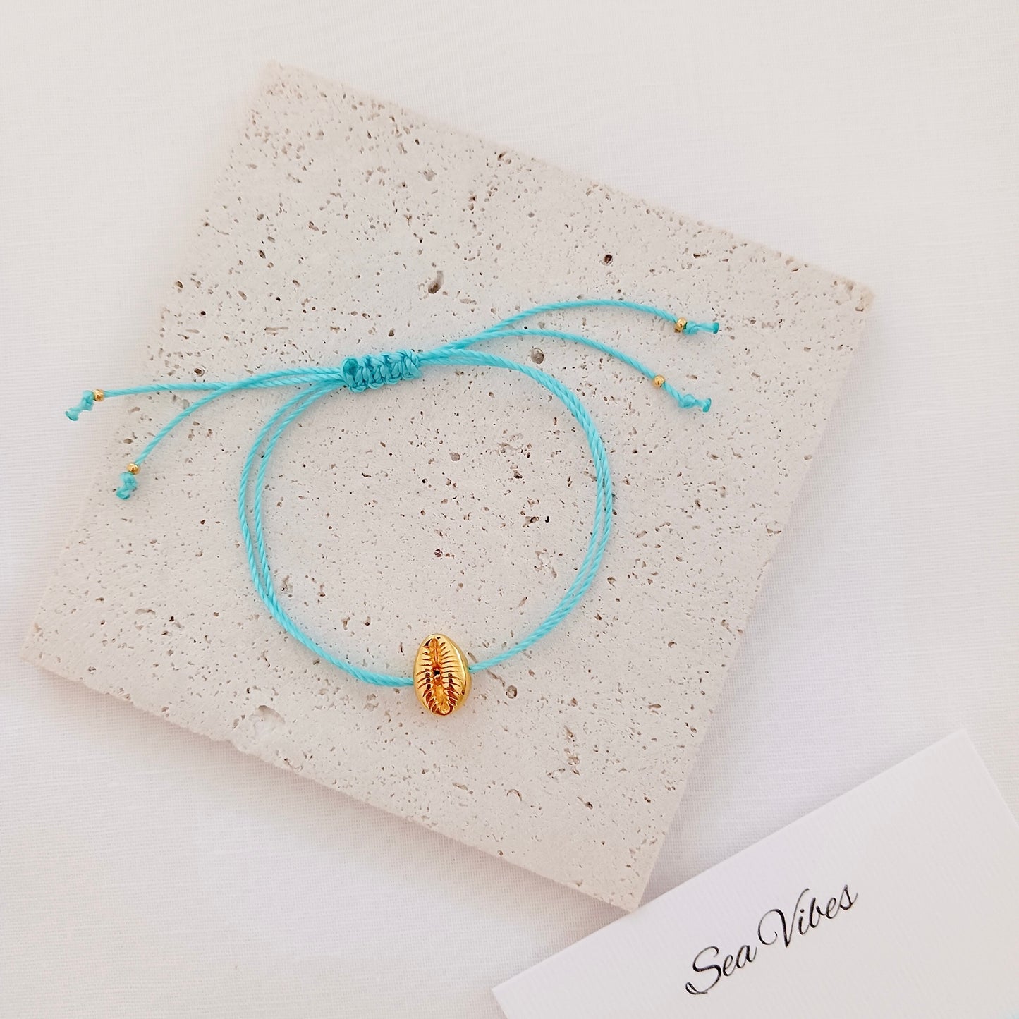 Gold shell charm cord bracelet