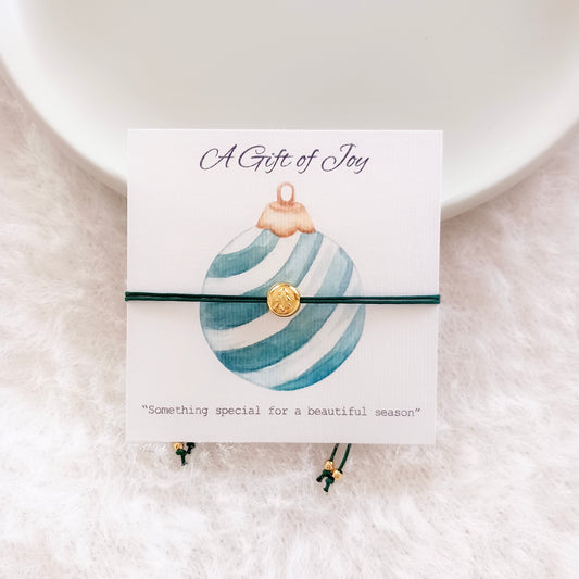 Bracelet cordon avec charm sapin de Noël sur carte de vœux